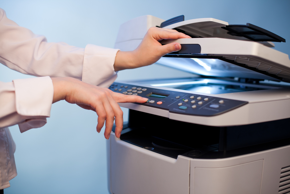 Woman’s hand with working copier